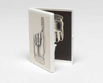 White plastic box with a Maciunas-designed label attached to the lid; a label is attached to the...