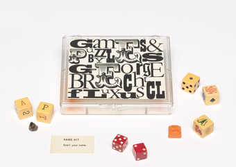 (.1) 7-compartment clear plastic box with a Maciunas-designed label attached to the lid,...