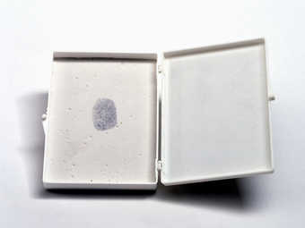 White plastic box with a label (black print on tan background) attached to lid; contains plaster...