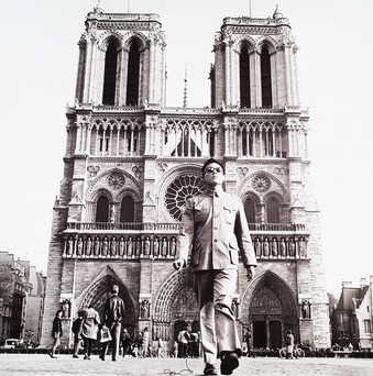 an image of the artist standing in front of Notre Dame Cathedral in Paris