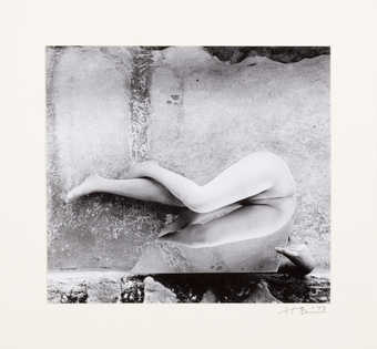 An image of a nude bending at the torso over a mirror.  The model is Ana Mendieta.
